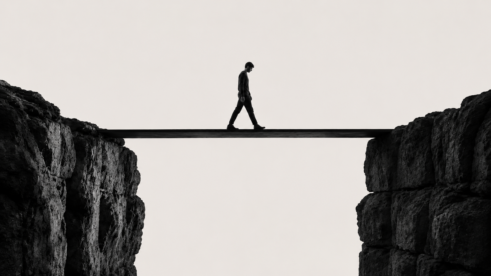 A figure walking a narrow plank bridge across a gap between two cliffs.