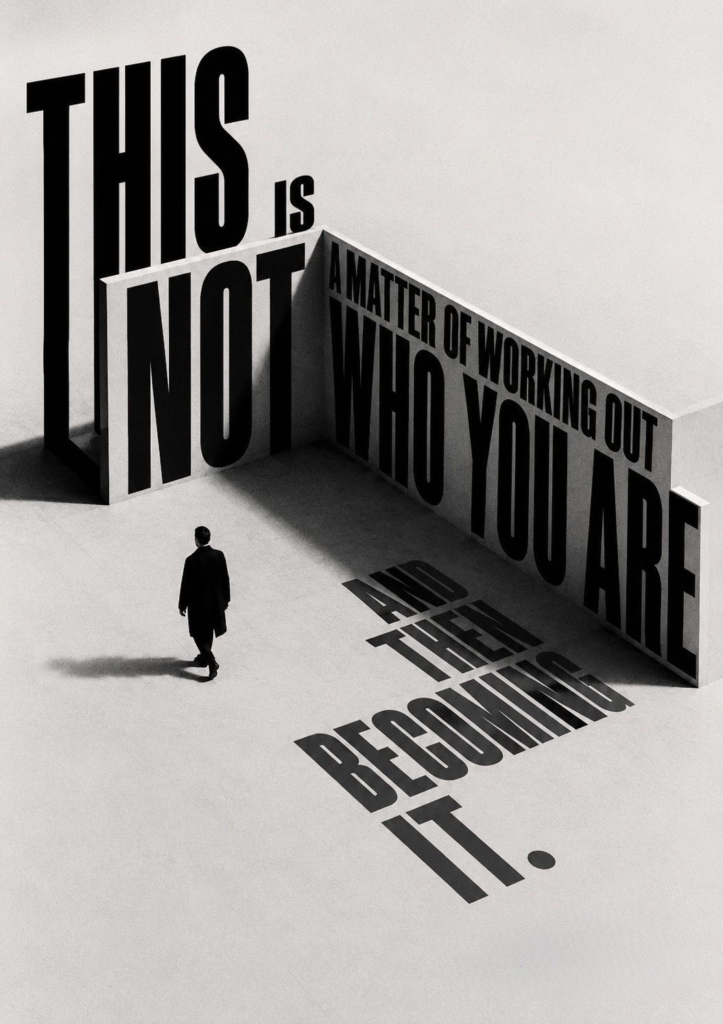 A lone figure walking past a monumental architectural corner of type reading ‘this is not a matter of working out who you are and then becoming it’, its final words cast as a long shadow across the floor.