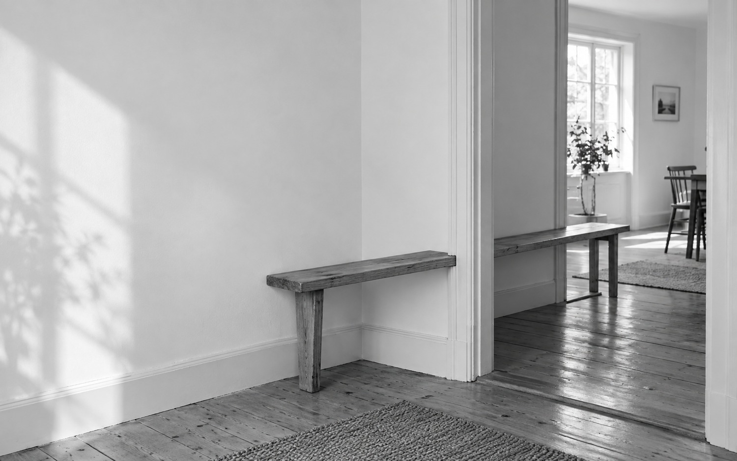 An empty wooden bench continues through a solid doorway jamb.