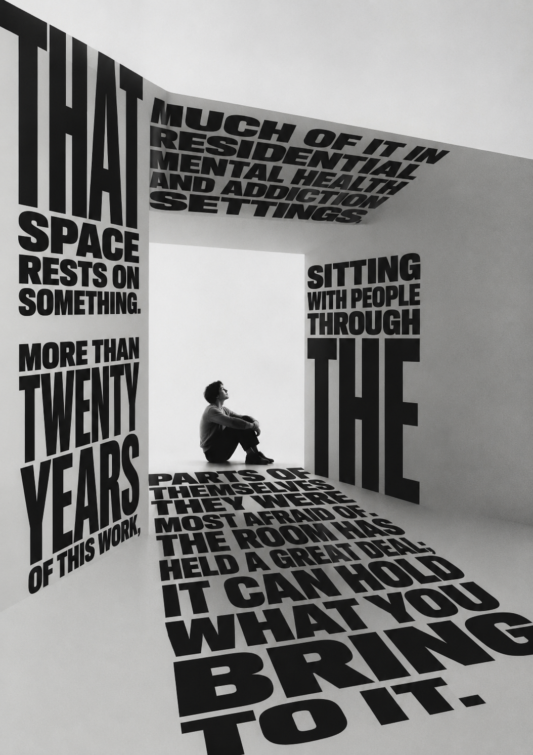 A room built from monumental words — that space rests on something: more than twenty years of this work — with a figure sitting quietly at its centre; the room has held a great deal, it can hold what you bring to it.